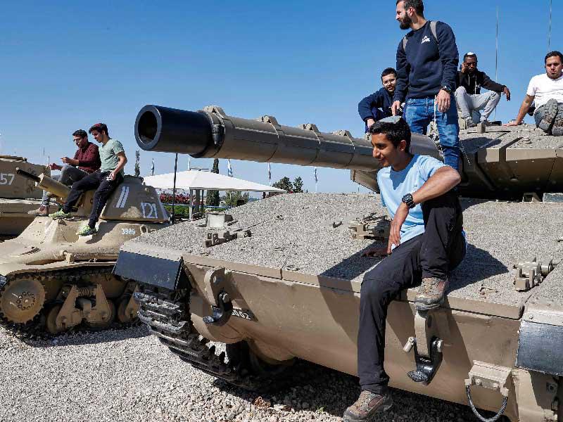 إسرائيليون على دبابات قديمة خلال مراسم إحياء ذكرى قتلى الحروب والعمليات العدائية في المرطون بين القدس وتل أبيب أمس	(أ ف ب) 