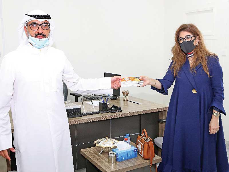 رئيسة فريق المسؤولية المجتمعية والمديرة العامة لحماية العملاء في البنك سحر دشتي تسلم قسائم الشراء إلى عبدالله الكندري من بنك الطعام