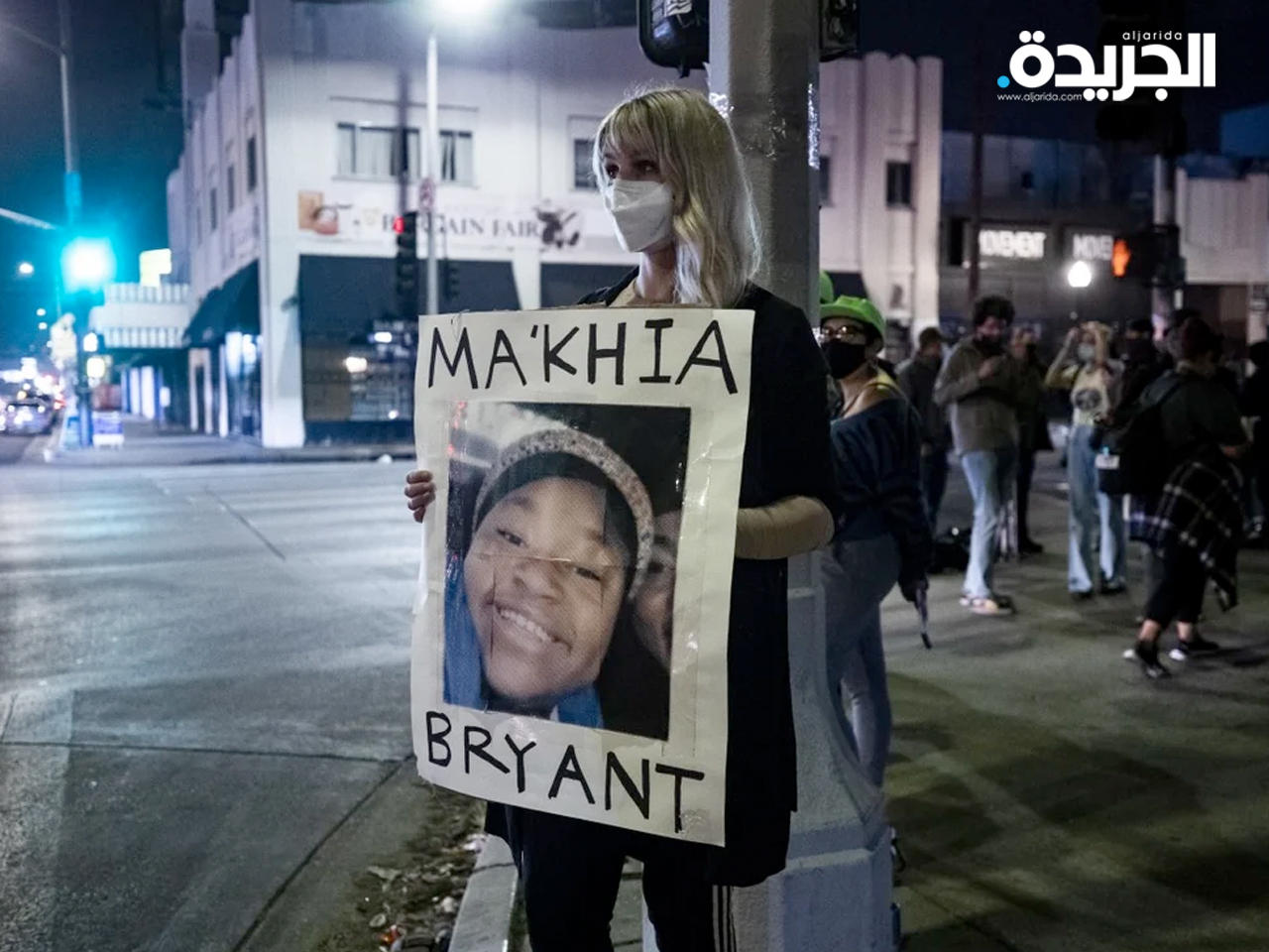 متظاهرة تحمل صورة القتيلة مكية برايانت