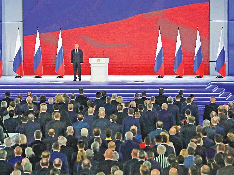 الرئيس الروسي فلاديمير بوتين مستمعاً إلى النشيد الوطني أمام البرلمان بمجلسيه في موسكو أمس (رويترز)