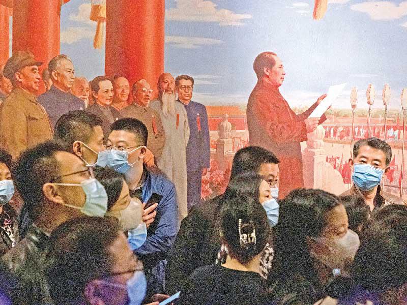 صينيون أمام لوحة تظهر الزعيم الشيوعي الصيني الراحل ماوتسي تونغ خلال معرض في ساحة تيانامين بذكرى 100 عام على تأسيس الحزب الشيوعي الصيني (رويترز)