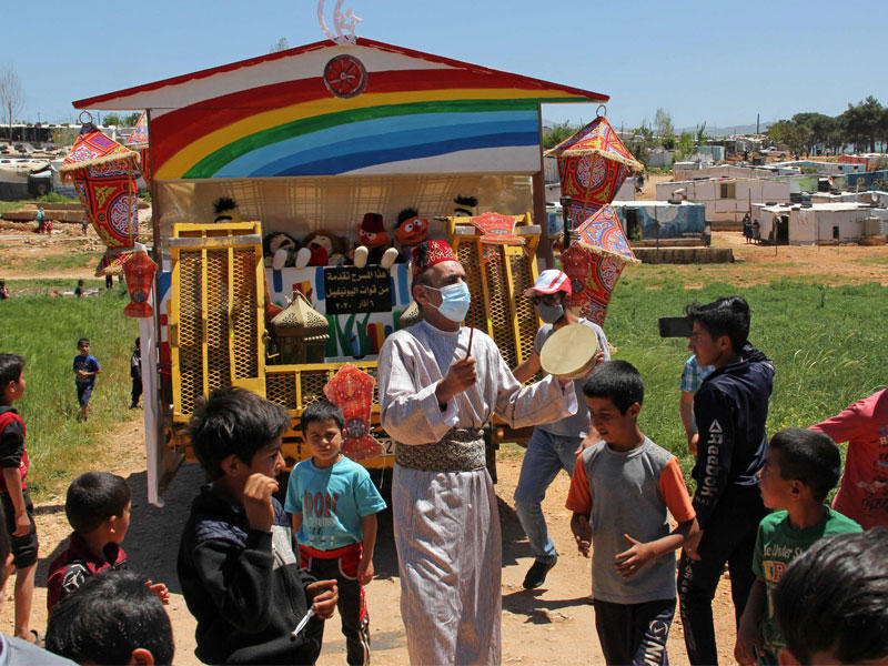 أطفال يتحلّقون حول مسحّراتي في مخيم للاجئين السوريين قرب بلدة إبل السقي جنوب لبنان (أ ف ب)
