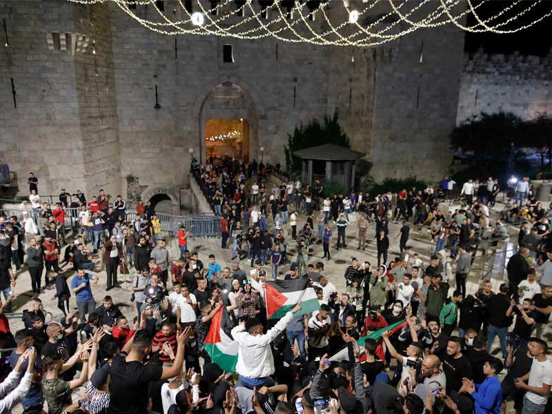 الفلسطينيون يحتفلون بإزالة الحواجز خارج باب العامود أمس الأول  (أ ف ب)