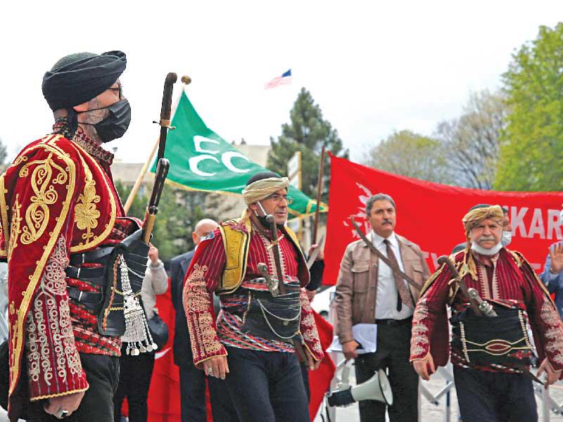 أعضاء في فرقة رقص شعبي تركية بلباس تقليدي خلال تظاهرة ضد بايدن قرب السفارة الأميركية في أنقرة أمس الأول  (رويترز)