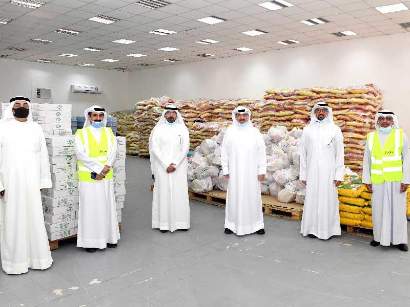 الرئيس التنفيذي للعلاقات والاتصالات في شركة زين الكويت وليد الخشتي ونائب رئيس مجلس إدارة البنك مشعل الأنصاري يتوسطّان مسؤولي «زين» وبنك الطعام خلال تقديم الماچلة