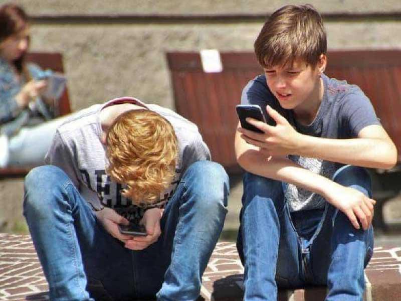 اطفال يتابعون الإعلانات الرقمية عبر هواتفهم المحمولة