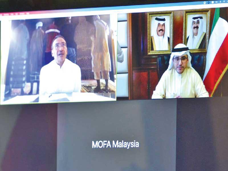  وزير الخارجية وزير الدولة لشؤون مجلس الوزراء، الشيخ الدكتور أحمد الناصر ونظيره الماليزي خلال الاتصال المرئي أمس