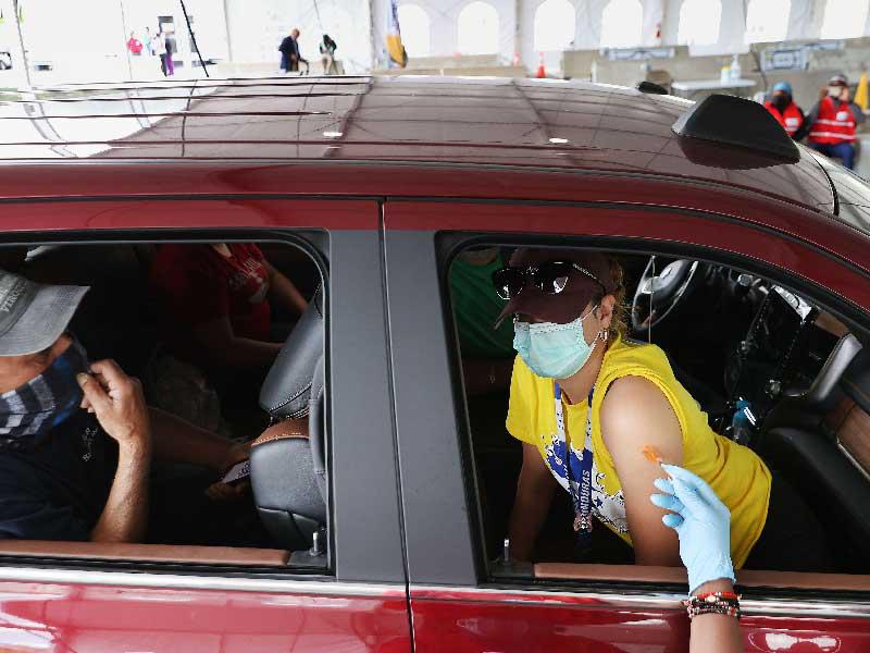 أميركيون يتلقون لقاح «كورونا» داخل سيارة في ماريلاند (أ ف ب)n