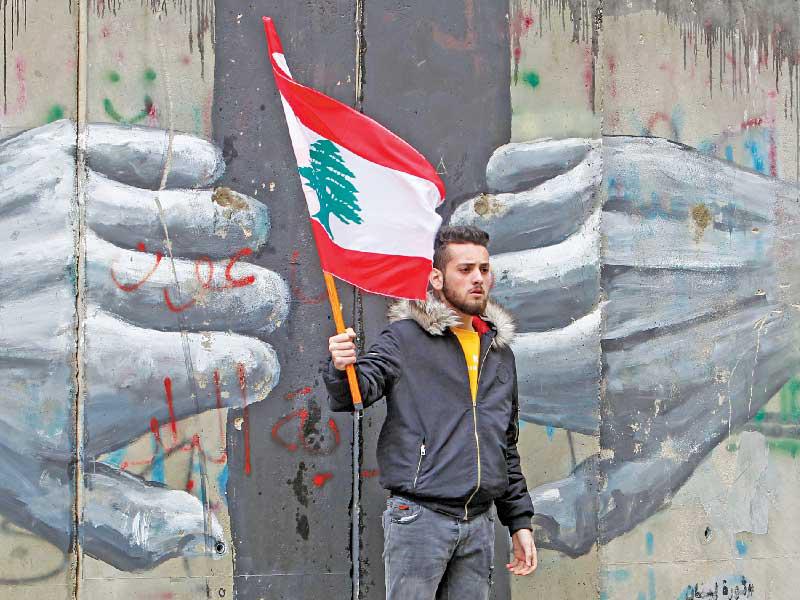 شاب يحمل علما لبنانياً خلال تظاهرة سابقة في بيروت (رويترز)n