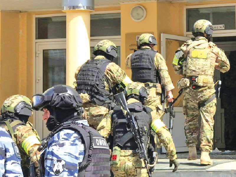 قوة أمنية تدخل المدرسة في قازان بعد انتهاء عملية إطلاق النار أمس (رويترز)