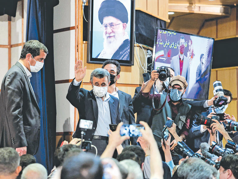 نجاد يحيي أنصاره عقب تقديم أوراق ترشحه في طهران أمس (أ ف ب)