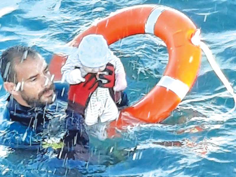 عنصر من خفر السواحل الإسباني ينقذ رضيعاً من البحر في مليلة أمس (ا ف ب)