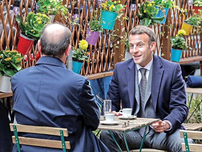 الرئيس الفرنسي إيمانويل ماكرون يحتسي القهوة على مقهى في باريسn