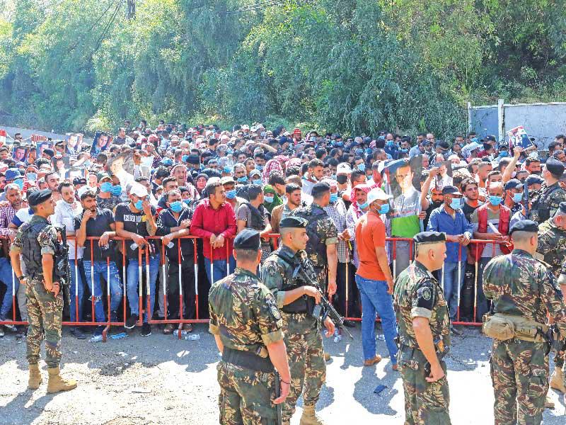 آلاف السوريين أمام سفارتهم بلبنان بانتظار دورهم للتصويت أمس      (أ ف ب)