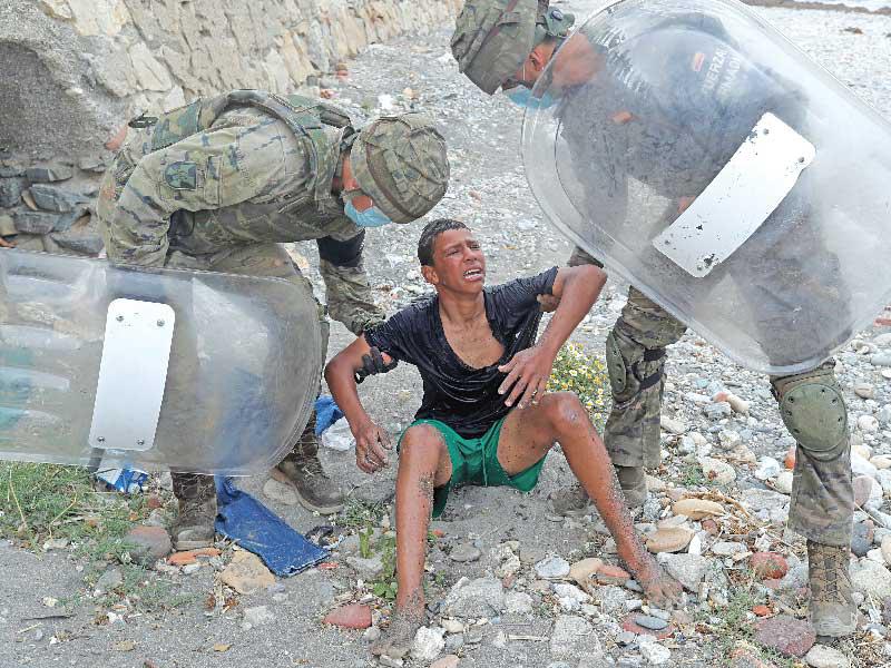 جنديان إسبانيان يوقفان فتى مغربياً تمكن من العبور إلى مليلة تمهيداً لترحيله         (رويترز)