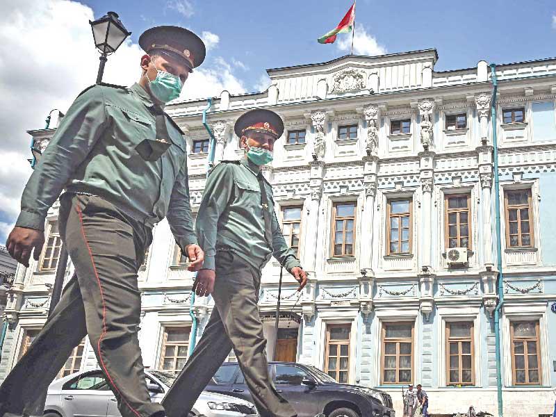 شرطيان روسيان يمرّان أمام سفارة بيلاروسيا في موسكو أمس t(أ ف ب)