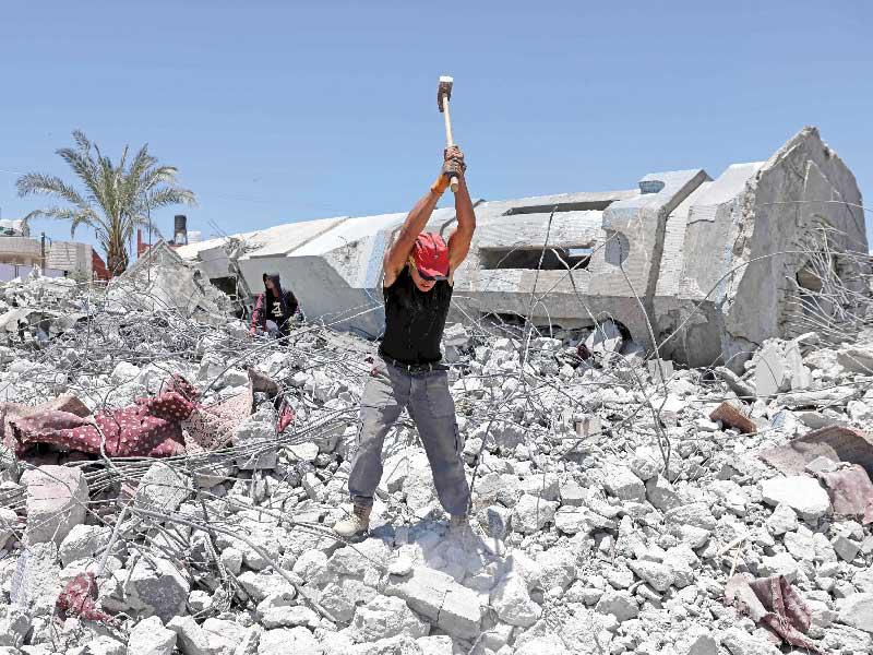 فلسطيني يكسر أنقاض مسجد مدمر في بيت لاهيا أمس  (أ ف ب)