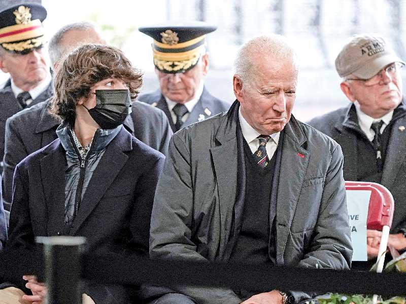 الرئيس الأميركي جو بايدن وحفيده خلال إحياء قداس يوم الذكرى في ديلاوير أمس الأول t(رويترز) 