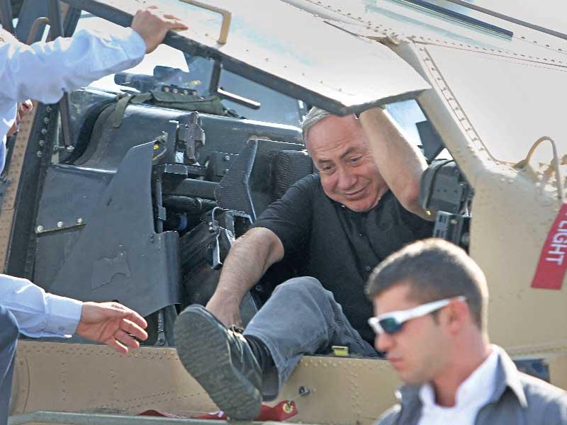 رئيس الوزراء بنيامين نتنياهو يحاول الخروج من مروحية أباتشي في 2016 (أ ف ب)