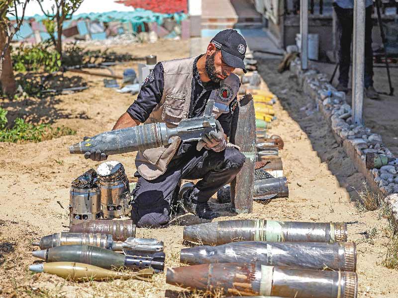 خبير متفجرات في «حماس» يفرز الصواريخ غير المنفجرة في غزة أمس         (أ ف ب)