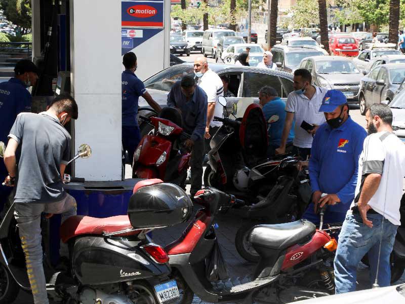 عامل يملأ دراجة نارية بالوقود في محطة وقود في بيروت ، لبنان