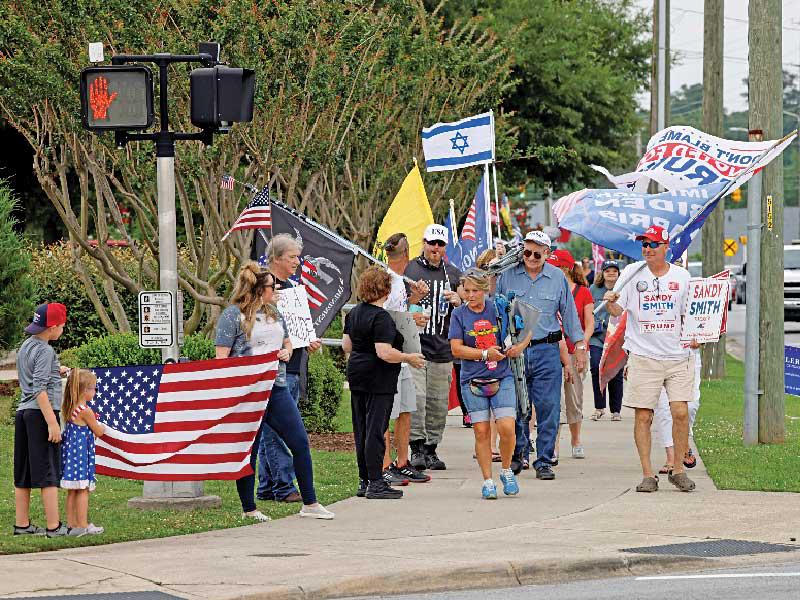 أنصار الرئيس السابق دونالد ترامب في طريقهم إلى القاعة حيث ألقى كلمة في غرينفيل أمس الأول (رويترز)