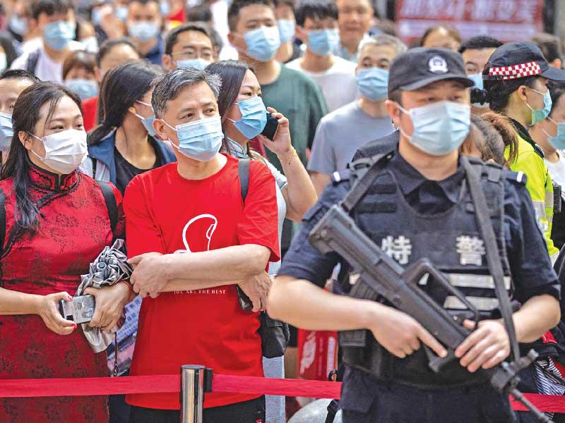 أهالي ينتظرون انتهاء ابنائهم من إجراء امتحان دخول إلى الكلية الوطنية في ووهان أمس (ا ف ب)