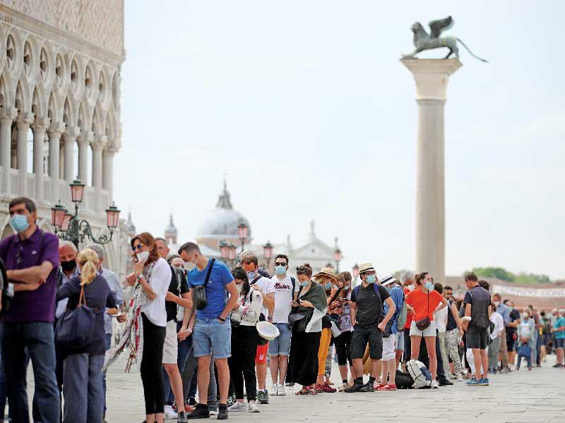 سياح ينتظرون لدخول كاتدرائية سان ماركو في البندقية الإيطالية أمس   (رويترز)