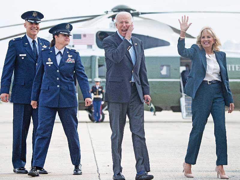 الرئيس جو بايدن وزوجته يودّعان الصحافيين في قاعدة أندروز الجوية أمس قبيل توجههما إلى الطائرة الرئاسية في طريقهما إلى لندن (أ ف ب)