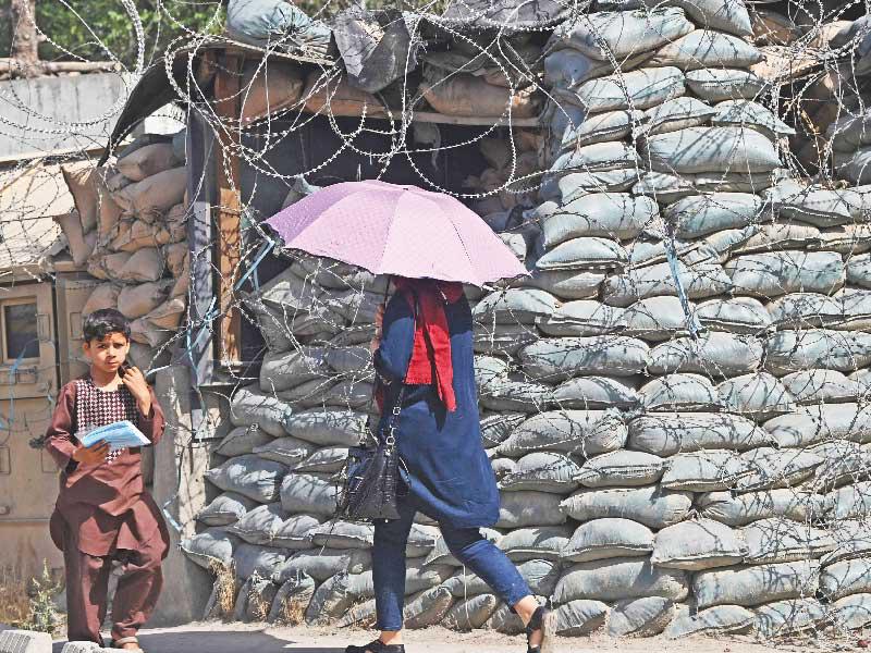 امرأة وطفل يمران أمام نقطة تفتيش محصّنة في كابول أمس t(أ ف ب)