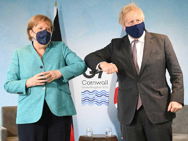 رئيس الوزراء البريطاني بوريس جونسون والمستشارة الألمانية أنجيلا ميركل خلال لقائهما أمس (رويترز)