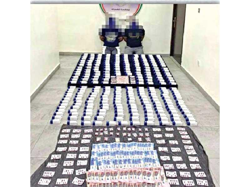 المتهمان وأمامهما المضبوطات 