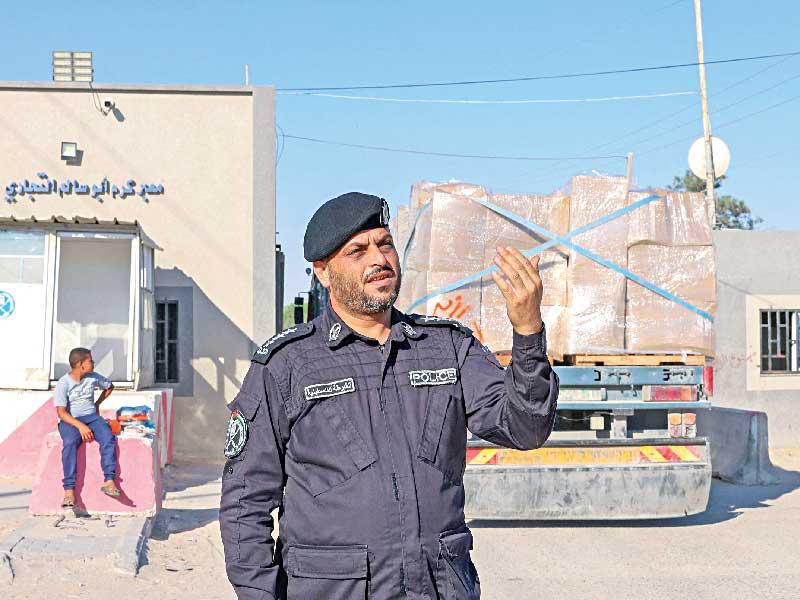 شرطي فلسطيني خلال عبور بضائع للتصدير من غزة معبر كرم أبو سالم أمس (أ ف ب)