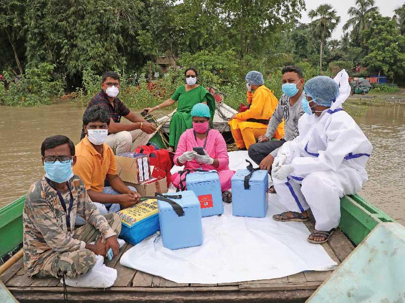 عمال رعاية صحية يعبرون نهر مونديسواري في قارب لتلقيح القرويين في جزيرة أوتار باتورا في ولاية البنغال الغربية بالهند أمس (رويترز)