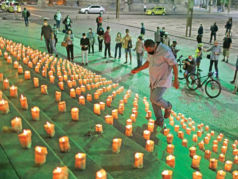 شموع أضيئت أمس لتكريم نصف مليون برازيلي قضوا بـ«كورونا» في ريو دي جانيرو  (رويترز)
