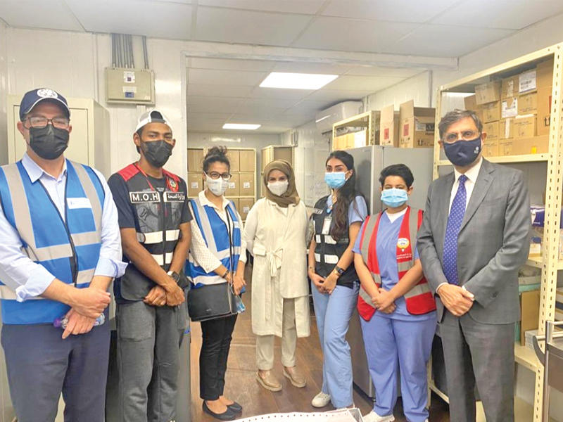 الممثل الدائم لـمكتب منظمة الصحة العالمية في الكويت د. أسعد حفيظ مع طاقم الصيدلية في مركز التطعيم بالسيارات في جسر جابر وبدت د. رحاب الوطيان