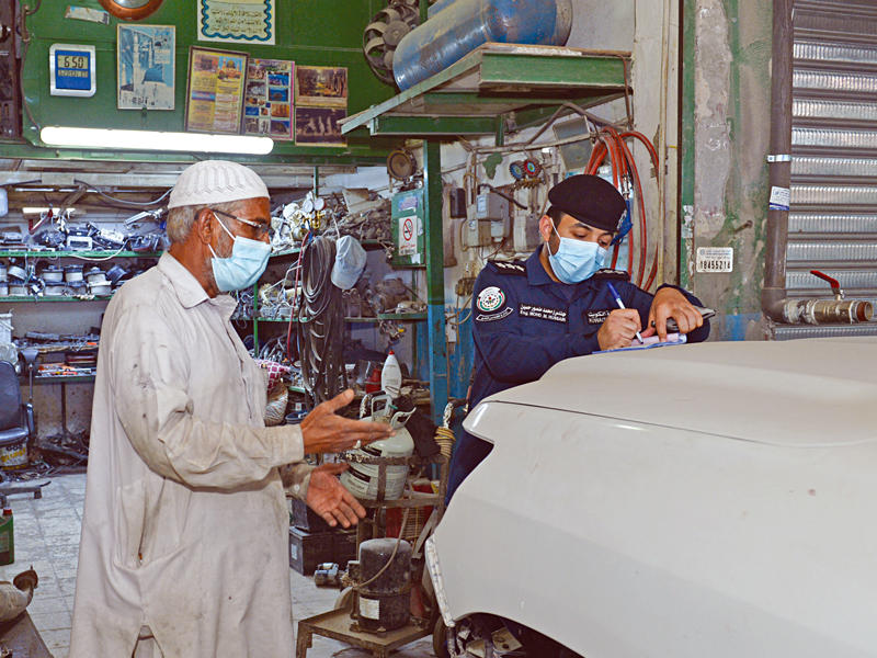 تحرير مخالفة لأحد الكراجات وفي الإطار مركبة متهالكة قيد التزوير (تصوير جورج ريجي)