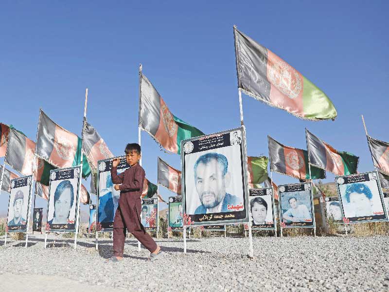 فتى أفغاني يمر أمام مقبرة لضحايا القتال مع «طالبان» في كابول (رويترز)