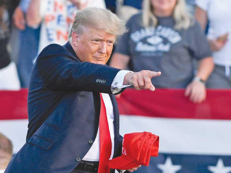 ترامب يستعد لرمي قبعات تحمل اسمه على مناصريه في أوهايو أمس الأول (رويترز)
