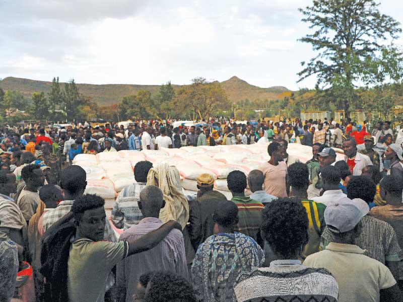 لاجئون هربوا من المعارك الأخيرة في مدينة شاير بإقليم تيغراي ينتظرون حصولهم على مساعدات غذائية   (رويترز)