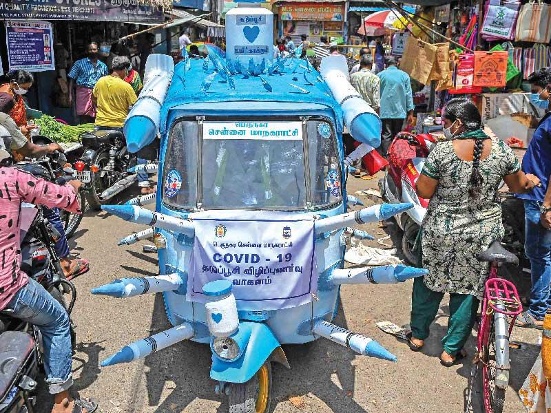 «توك توك» يروج للقاحات في شوارع مدينة شيناي الهندية  (أ ف ب)