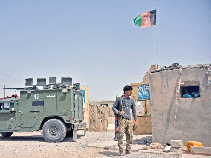 عنصر أمن أفغاني يحرس مدخل أحد مقار الجيش في قندهار أمس (أ ف ب)