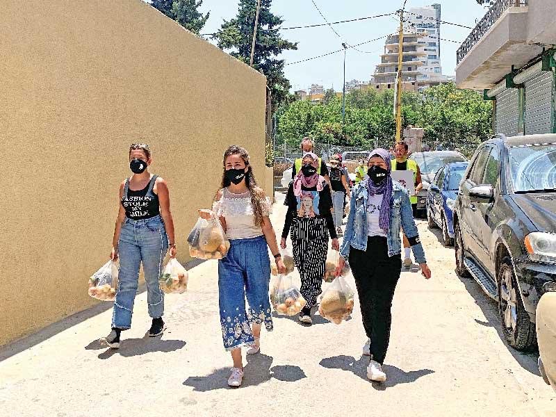 متطوعات يوزعن مساعدات غذائية في بيروت (رويترز)