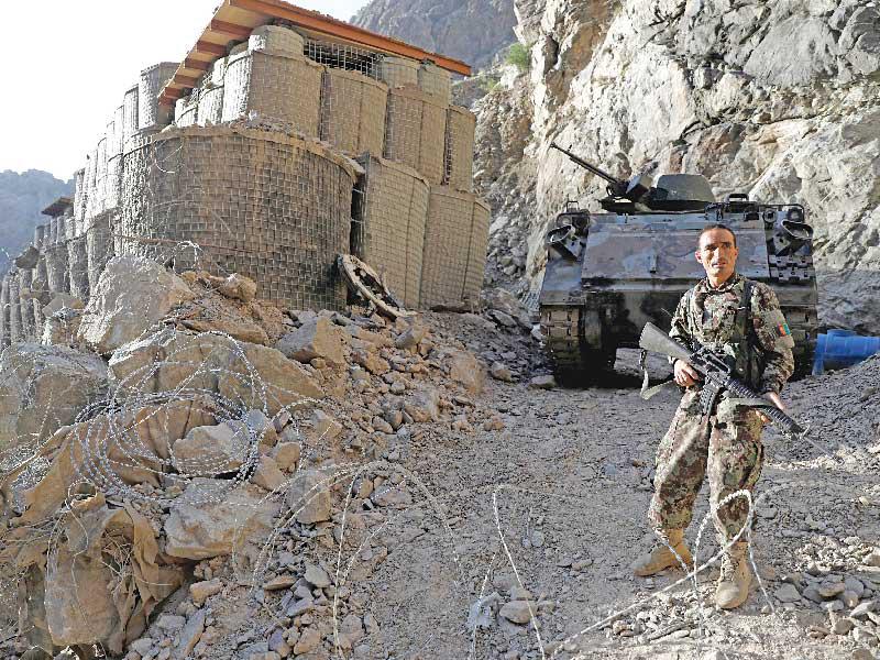 جندي أفغاني في إحدى النقاط المتقدّمة على مرتفع فوق الخط السريع جلال آباد ـــ كابول أمس  (رويترز)