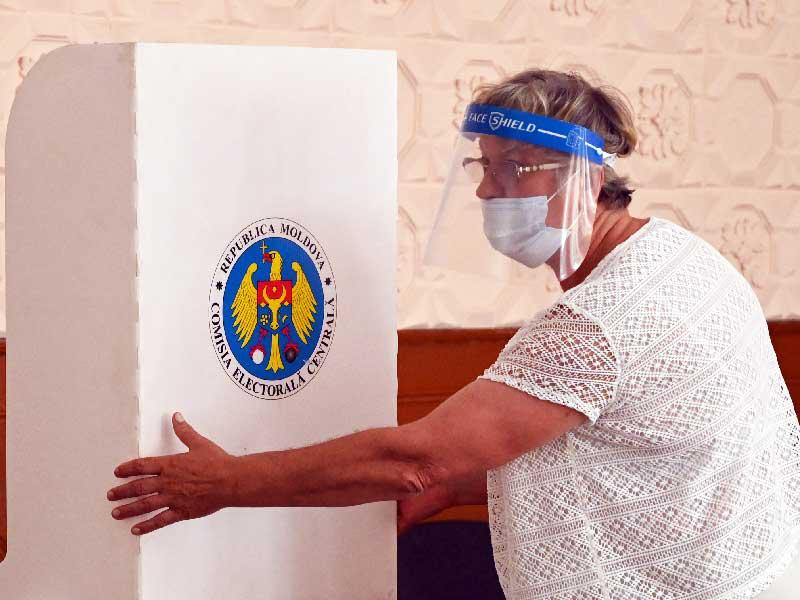 عضو في لجنة انتخابية محلية نصب كشك اقتراع في مركز اقتراع