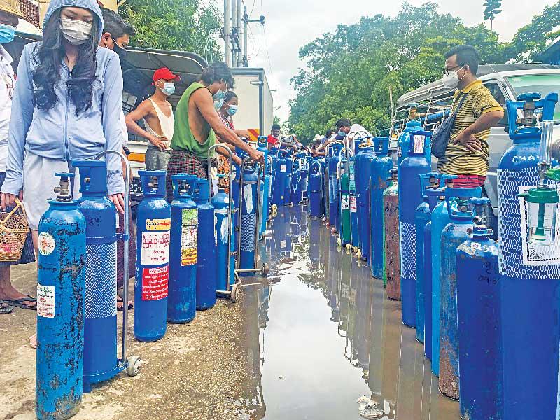 بورميون ينتظرون لتعبئة أسطوانات الأوكسجين في العاصمة رانغون أمس (أ ف ب)