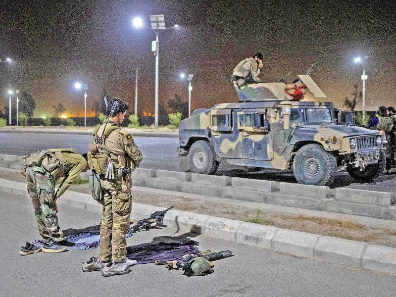 جنديان من القوات الخاصة يصليان على الطريق السريع في قندهار مساء أمس الأول t(رويترز)