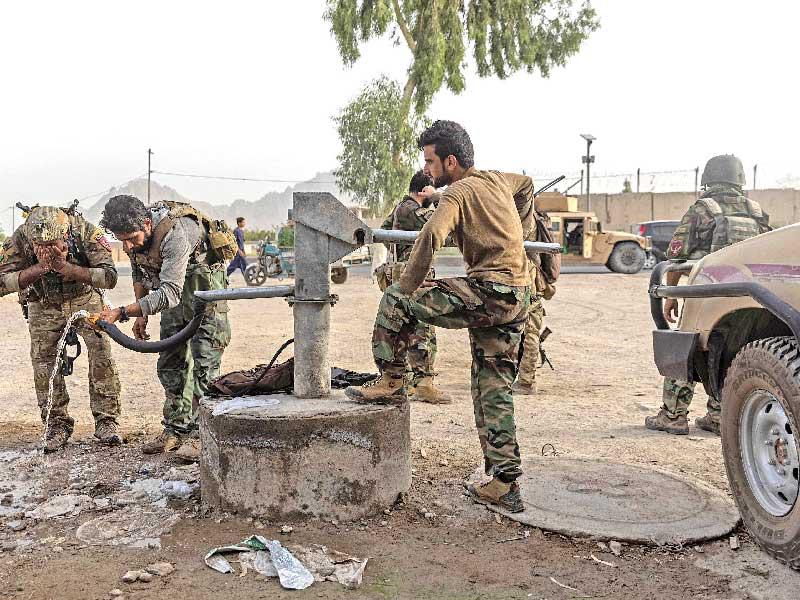 عناصر من الوحدات الخاصة يشربون الماء بعد مواجهات عنيفة مع «طالبان» في قندهار أمسt (رويترز)