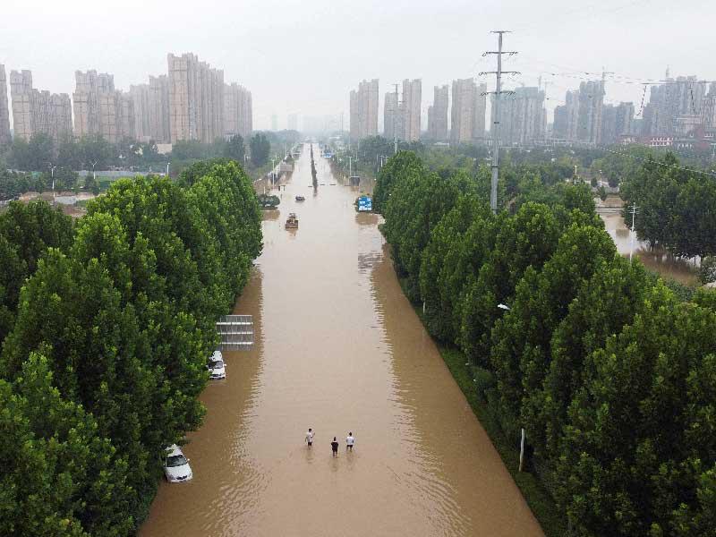 مياه الأمطار تغمر أحد الشوارع في مدينة زينغزو الصينية (رويترز)
