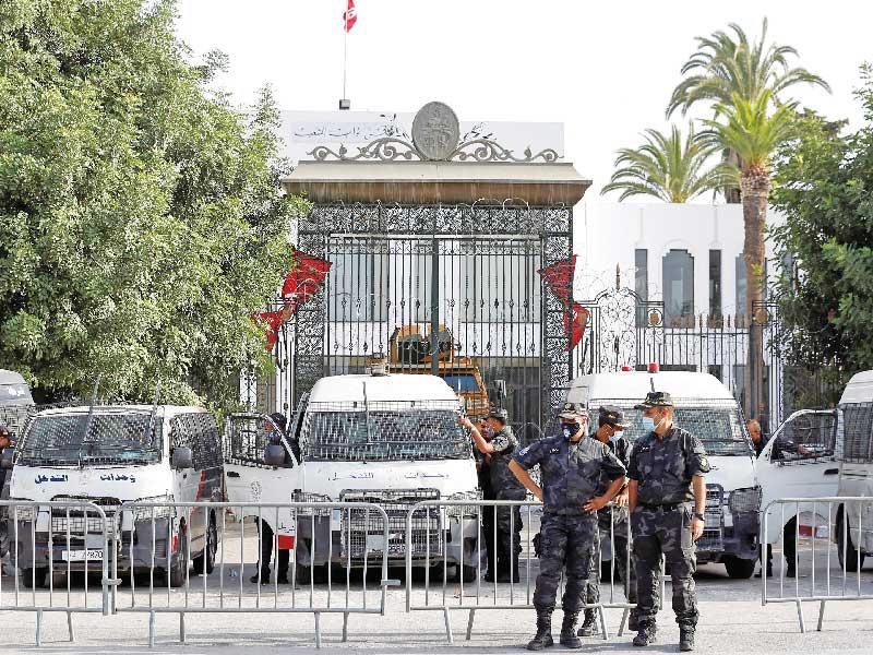 ضباط شرطة أمام مبنى البرلمان في تونس أمس (رويترز)